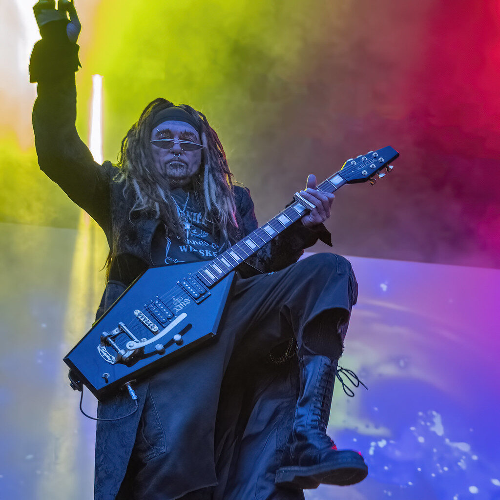 A older man with dreadlocks plays a guitar