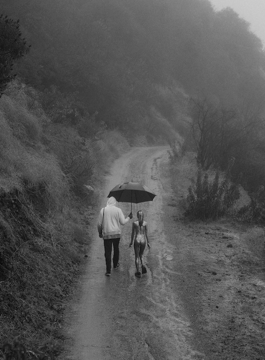 One members of FBZ walks with one of the models under an umbrella