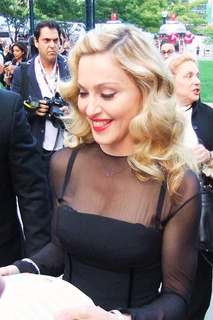 A woman in a black dress signs autographs