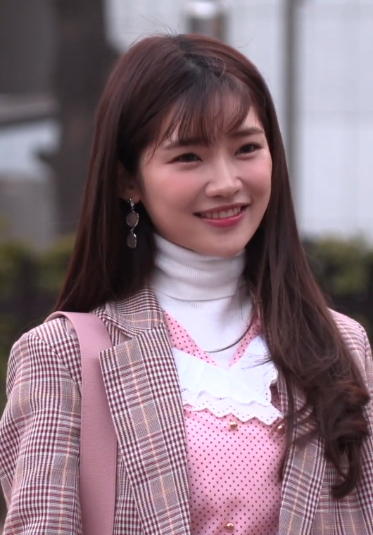 A young Asian woman in a pink outfit posing for a promotional image