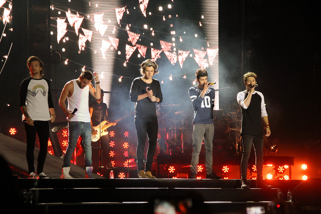 One Direction on stage. From left to right: Louis, Liam, Harry, Zayn, Niall.