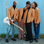 Black Haus group photo of four people in orange jackets