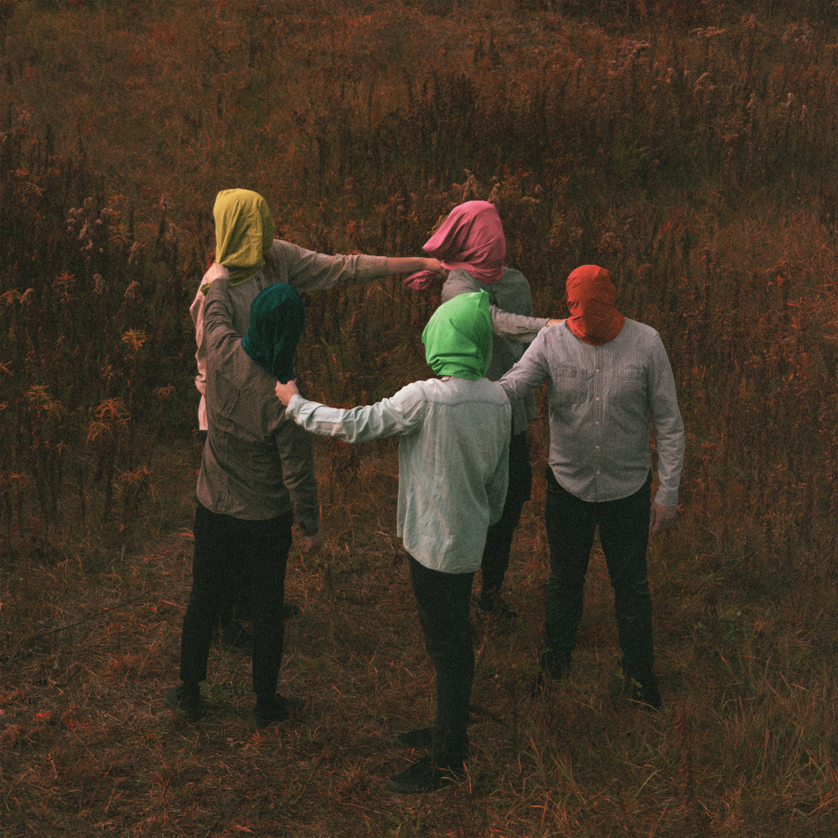 Album art for Celebrity Therapist by The Callous Daoboys. 5 people standing in a circle in a field, each holding the shoulder of the person in front of them. They're each wearing a bag of fabric over their head, one is red, one is lime green, one is dark green, one is yellow, and one is pink.