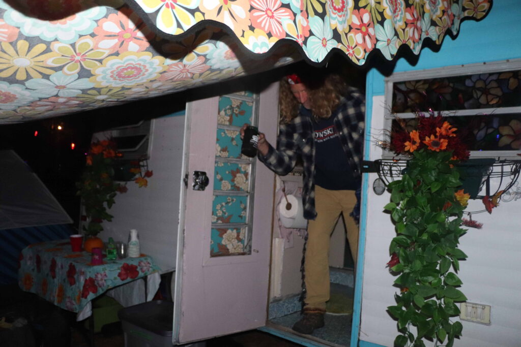 A man stepping out of his very beautifully decorated tent.