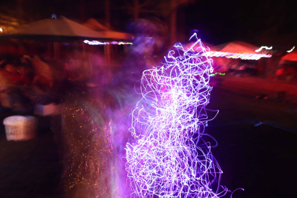 A woman playing with beaded lights caught on raw film. 