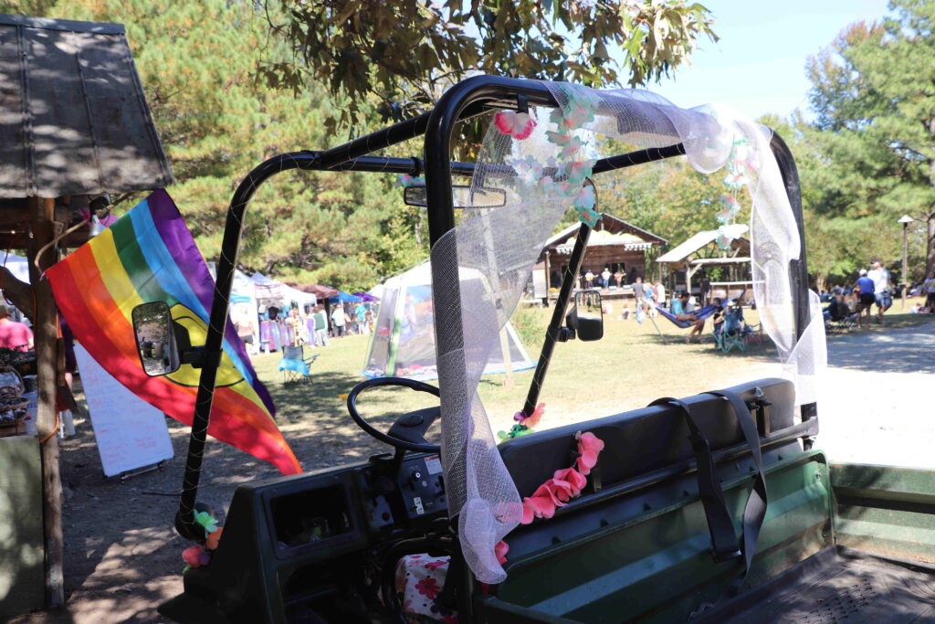 A picture of a decorated golf cart and one of four performance stages. 