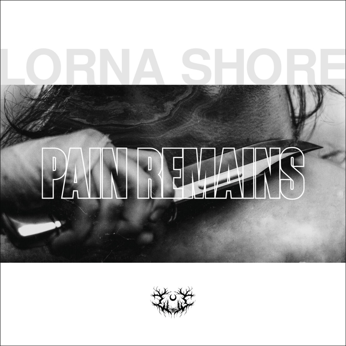 Lorna Shore, "Pain Remains" cover art. Black and white image of someone holding a knife to skin.
