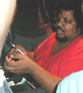 Photograph of Wesley Willis with a pen in hand.