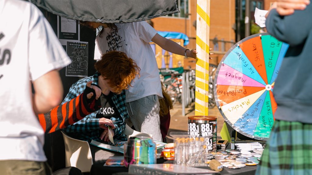 DJ in front of the WKNC prize wheel