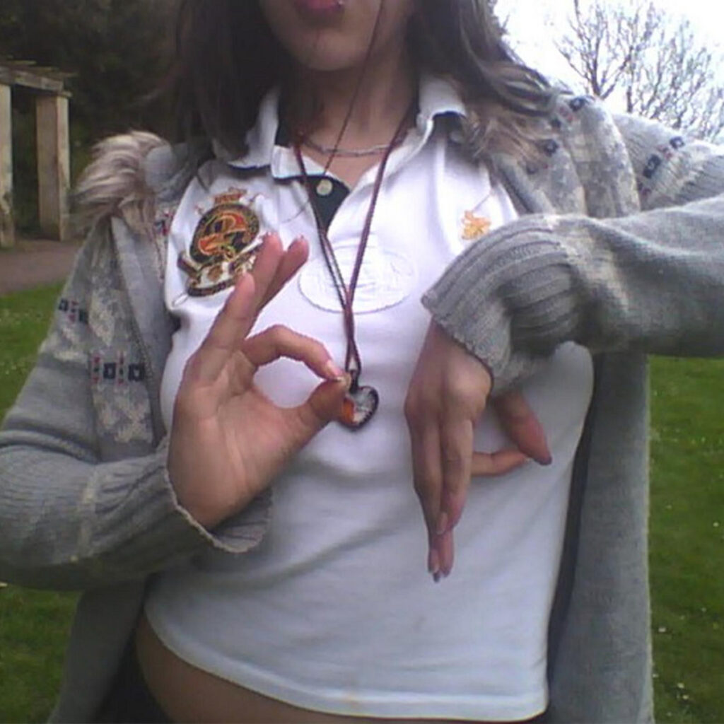 The album cover of "Basspunk" by Bassvictim, featuring the torso of a woman in a crop top and gray knit jacket with her hands positioned to spell "b p."