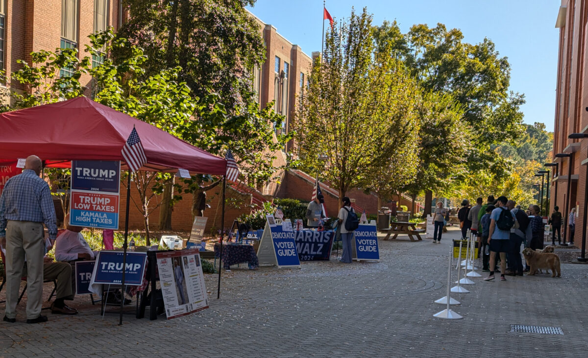 Early voting site at Talley Student Union featuring a line of voters on the right and tables supporting candidates Donald Trump and Kamala Harris on the left.