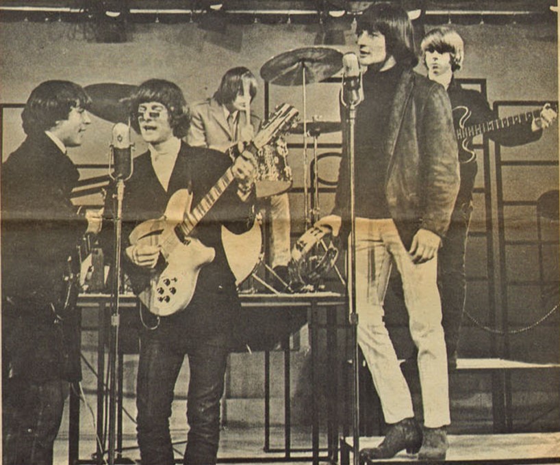A faded yellow image of the band The Byrds performing a show.