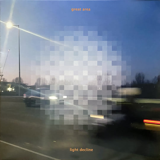 a picture of a parking lot at dusk with a large pixelated area obscuring the middle of the image. Yellow text on top reads great area, and yellow text on the bottom reads light decline.