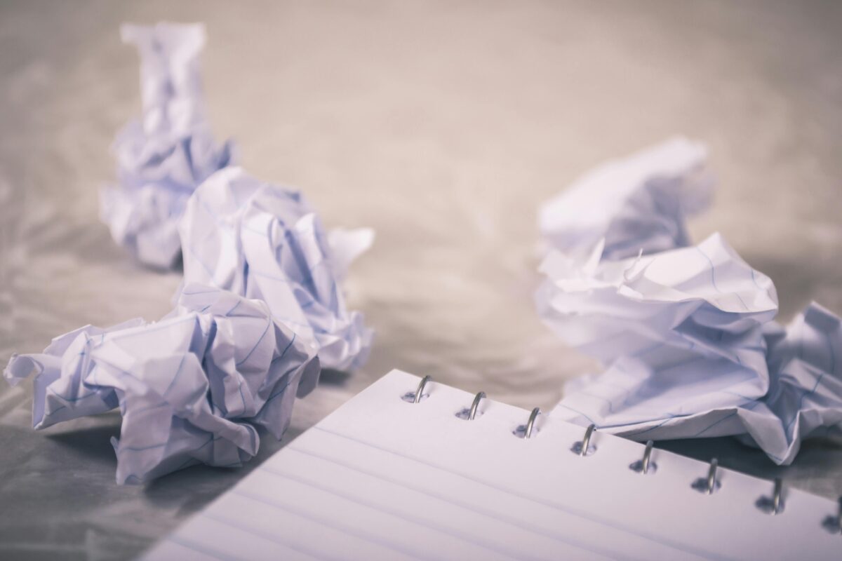 Balled up paper by a notebook