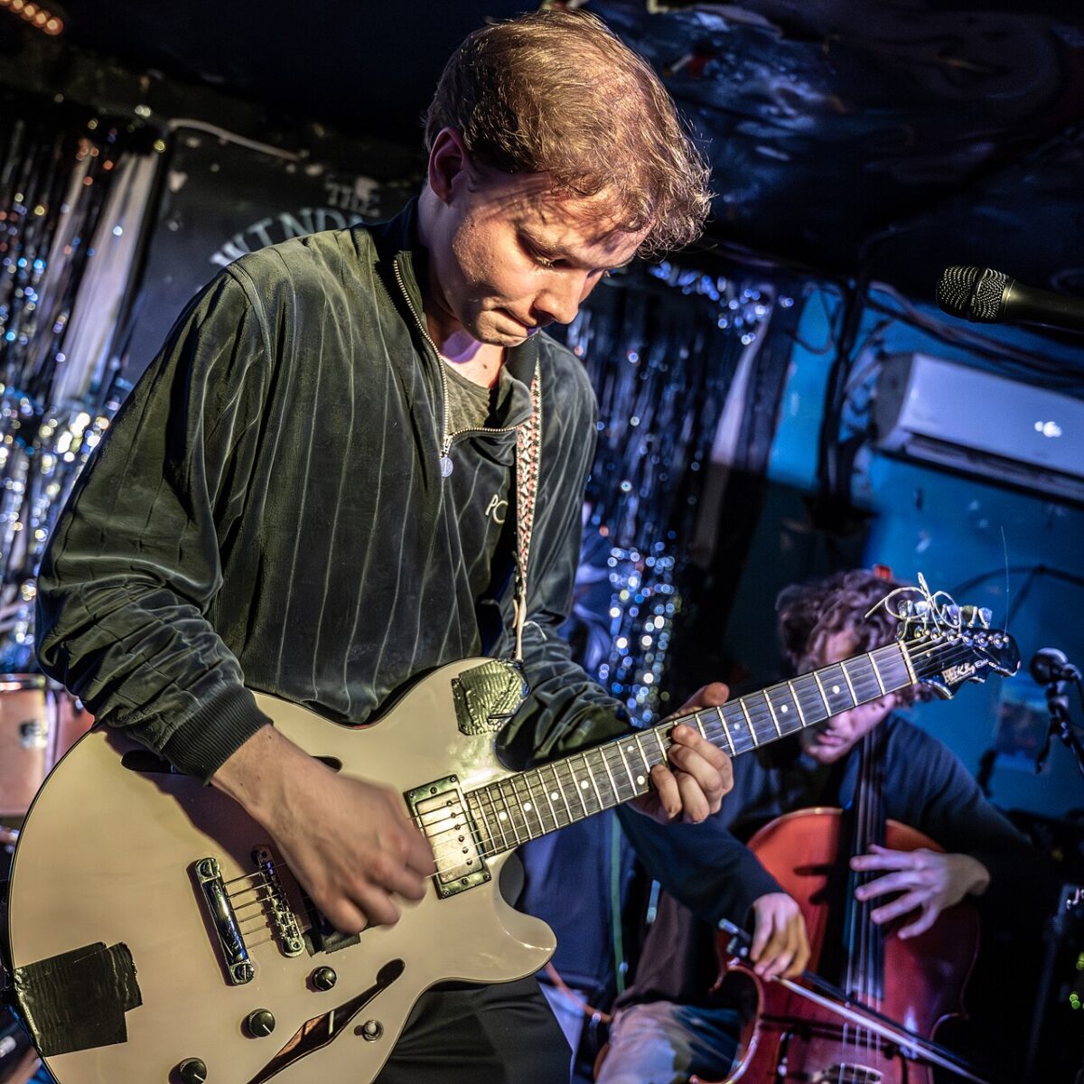 Geordie Greep playing guitar on stage