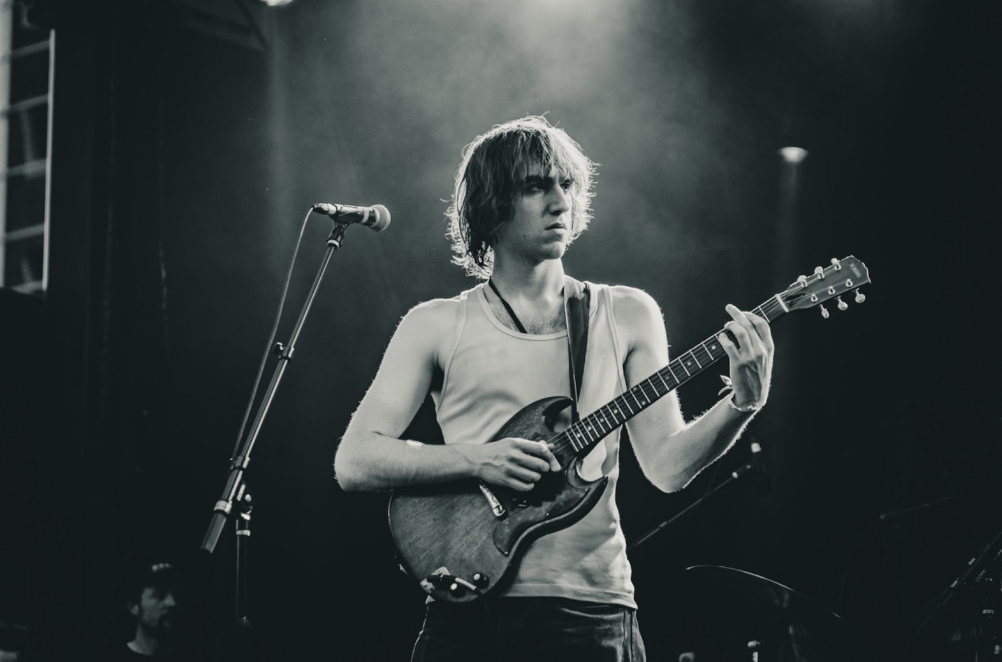 Cameron Winter of Geese plays guitar on stage in black and white photo from Hopscotch