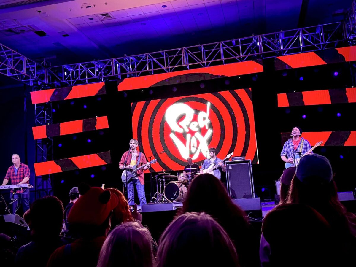 Red Vox perform to a crowd at Super MAGFest 2025; 5 Members of the band are on stage playing instruments.