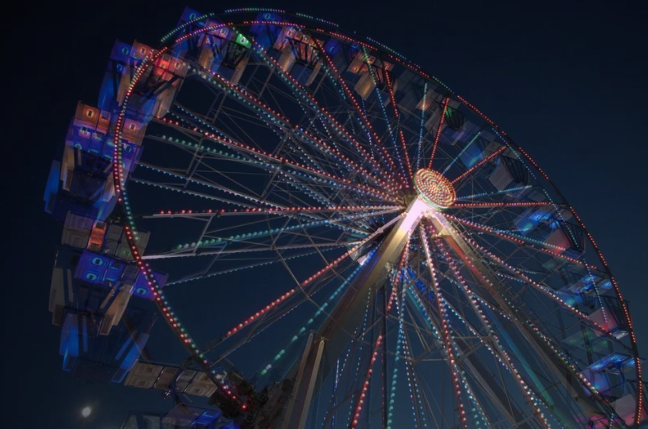 double exposure of wheel at fair, red and blue lights from ground up