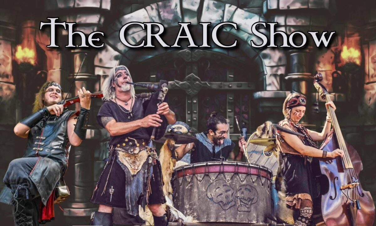 Four performers in kilts and furs on a stage with instruments