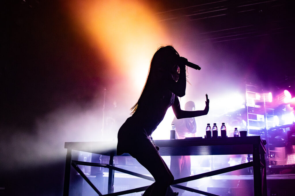 Snow Strippers' Tatiana Schwainger posed silhouette with producer Graham Perez watching from behind the table on stage.