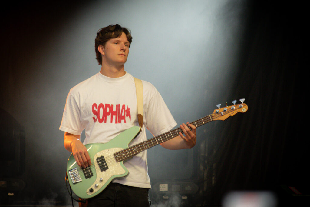 Odd 39's bassist with white light beaming down on him.