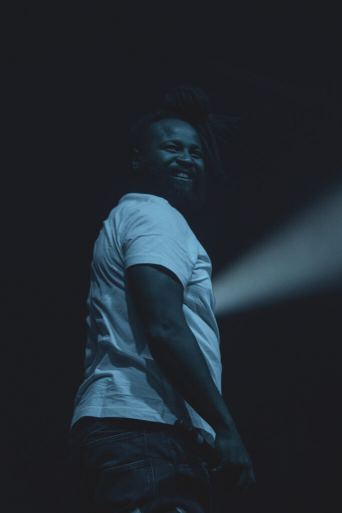 K CAMP's hype man with a beam of light behind him.