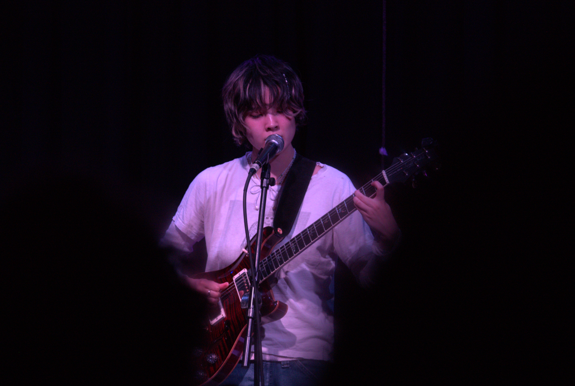 Mei Semones singing and playing guitar