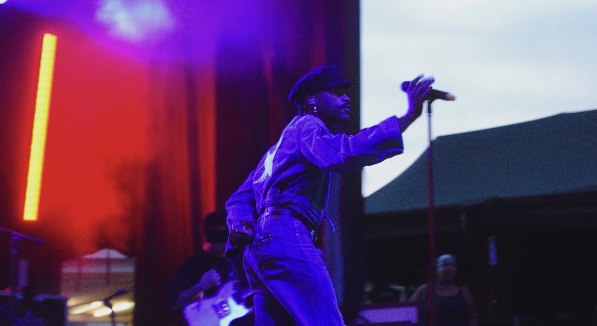 A man moving on stage to get a microphone.